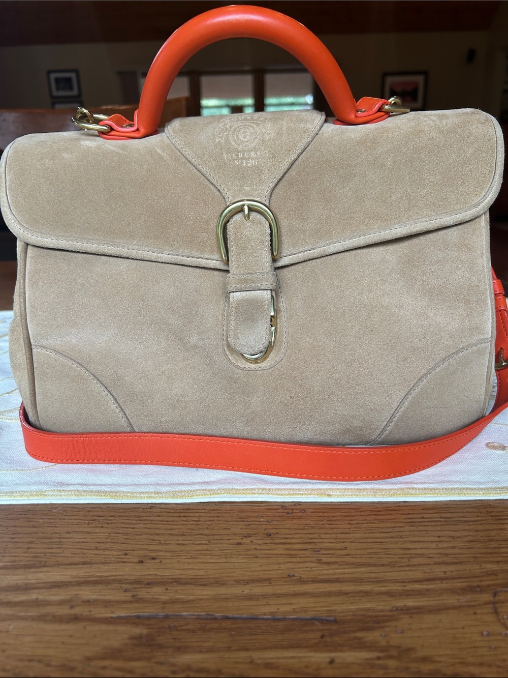 Ghurka tan suede handbag with orange leather details.